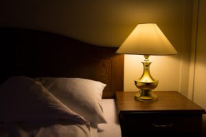 Lamp on a night table next to a bed